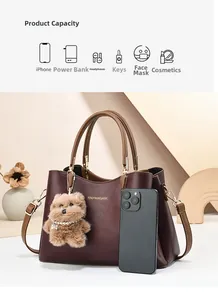 Detail view of burgundy handbag showing size comparison with smartphone and accessories