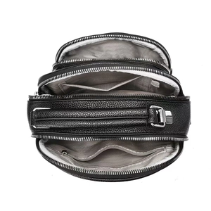 Top view of black pebbled leather bag showing multi-layer zippers and interior pockets
