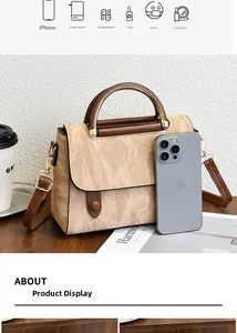 Détail du sac à main plissé beige avec poignées en cuir marron et finitions dorées