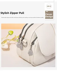 Detailed macro view of silver polished metal zippers on a white litchi grain leather bag