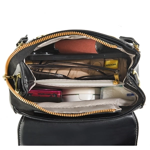 Vertical top view of black leather crossbody bag interior with multiple compartments