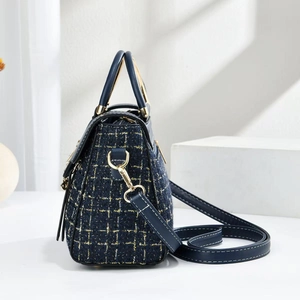 Close-up of navy blue tweed fabric with golden thread and premium metal hardware details