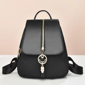 Zaino chic in pelle nera con cerniera dorata verticale e ciondolo sorridente alla moda