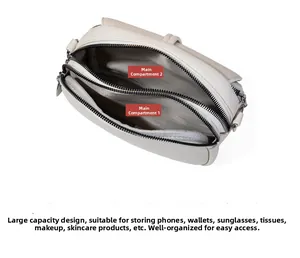 Detail of beige leather crossbody bag featuring dual zippered compartments and spacious interior
