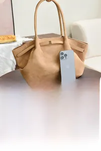 Macro shot of khaki suede tote bag interior featuring multi-compartment design and large capacity