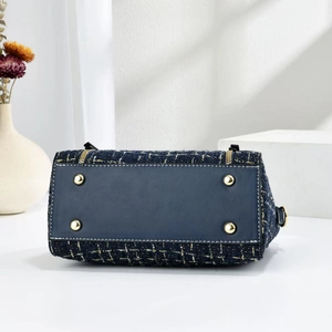 Detail view of the navy blue tweed handbag base with four protective gold metal feet