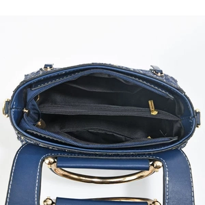 Macro view of the blue woven handbag interior with multiple compartments and gold zipper