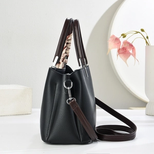 Borsa a mano in pelle nera con manico in sciarpa di seta su sfondo minimalista