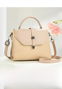 Close-up of beige messenger bag showing woven texture and smooth leather handle details