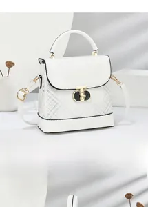 Detailed view of the grid pattern print and gold T-lock on the white crossbody bag
