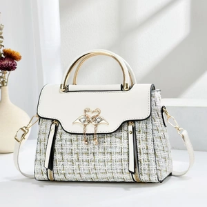 Elegant white tweed crossbody bag with gold flamingo clasp and pearl tassel detail