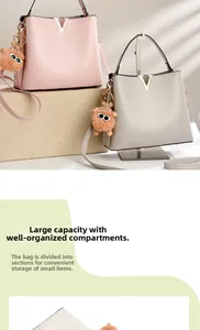 Detail view of premium PU leather crossbody buckets with elegant V-logo and fuzzy charms