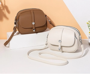 Detail of lychee pattern leather bags with three zipper compartments and buckles