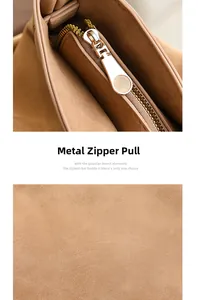 Close-up of golden metal zipper pull on camel suede tote bag with soft inner lining