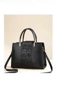 Detail of elegant black PU leather handbag featuring exquisite rose embroidery and gold hardware
