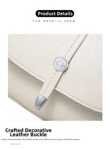 Detailed macro view of lychee-textured leather with silver cylindrical buckle and precise stitching