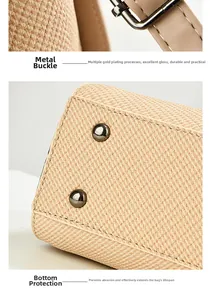 Detail of premium gold-plated hardware and protective base on beige tweed handbag