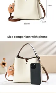 Detailed size comparison of beige bucket bag with phone and dimensions 22.5x11x20 cm