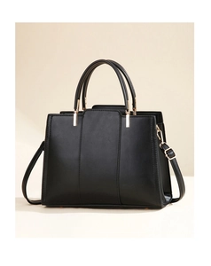 Detail shot of black faux leather handbag with vertical textures and gold hardware