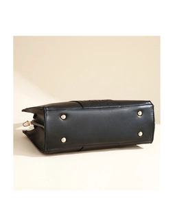 Detailed bottom view of elegant black leather handbag featuring four protective gold metal studs