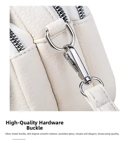 Macro detail of silver swivel hook on white lychee grain leather shoulder bag