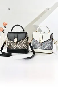 Detail of the chic ethnic geometric jacquard fabric and golden animal buckle on bag