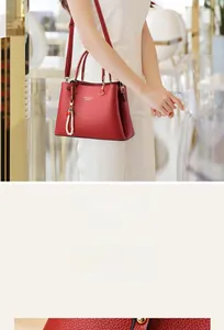 Detail of red pebbled faux leather tote bag featuring a pearl and cherry charm