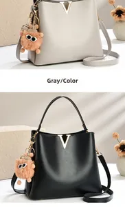 Detail of high-quality PU leather crossbody bag with metal V-buckle and cute bear charm
