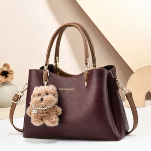 Elegant wine red leather tote bag for women with brown handles and plush dog charm