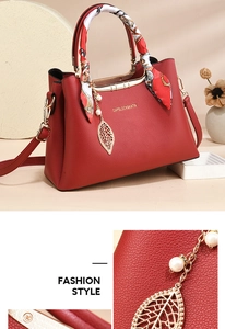 Detail of red bridal tote featuring litchi leather texture and silk scarf handle accent
