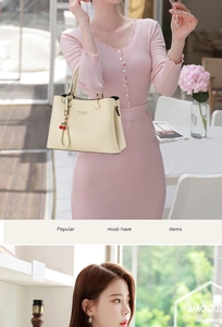 Detail of cream PU leather handbag featuring cherry charms and elegant pearl pendant