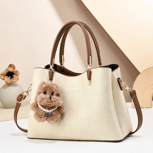 Elegant beige and brown contrast leather tote bag with stylish plush puppy charm
