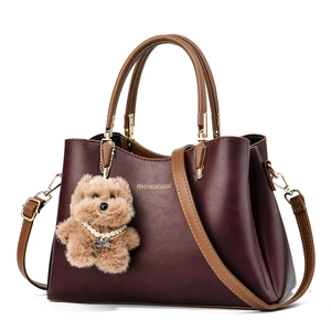 Elegant deep red PU leather handbag with brown handles and a cute bear pendant decoration
