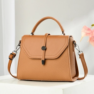 Brown woven patchwork messenger bag with top handle and adjustable shoulder strap on white stand