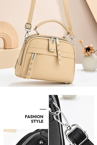 Detail view of lychee pattern leather bag with silver rivets and dual zipper closure