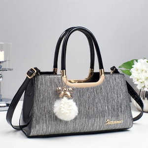 Détail du sac à main plissé argenté avec bordure en cuir verni noir et finitions dorées