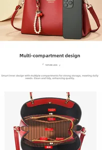 Red pebbled leather handbag detail showing internal compartments and cherry pearl charm