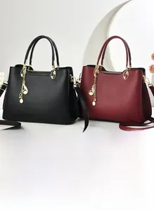 Détail de sacs en cuir grainé avec pendentif note de musique dorée et fermoir métallique