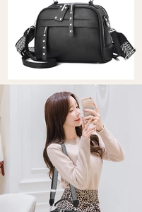 Detail of black textured handbag with silver studs and woven herringbone shoulder strap
