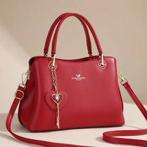 Elegant red faux leather tote bag for women with gold heart charm and crossbody strap