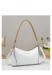 Detailed view of white crocodile pattern leather handbag with gold chain handle