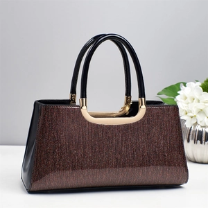 Détails du sac pailleté café avec anses en laque noire et boucle dorée élégante