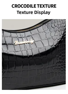 Close-up of black crocodile pattern glossy leather with gold metallic brand logo