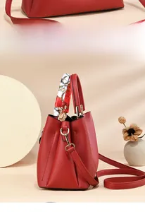 Close-up of red lychee grain leather wedding tote bag with decorative silk scarf handle