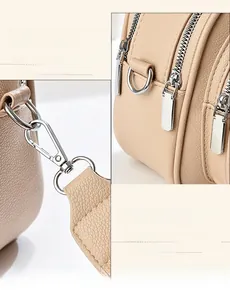Detailed close-up of premium gold-tone zippers and hardware on a leather handbag