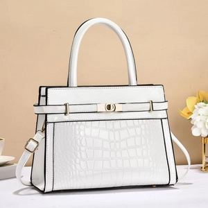 Detail of white crocodile embossed leather bag with gold buckle and smooth strap texture