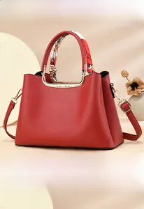 Detail of red bridal tote bag with lychee texture and silk scarf wrapped on metal handle