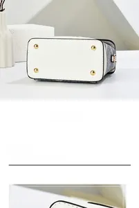 Detailed view of the mini bag's cream PU leather base with four protective gold metal studs