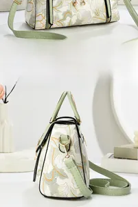 Detail showing mint green leather trim and floral print with golden metal hardware on bag