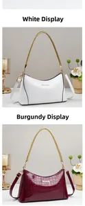 Detail view of glossy crocodile pattern hobo bags in white and wine red with gold chains